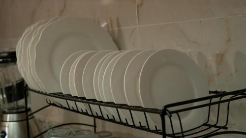 a stack of white plates on a wire shelf at Banana Surf Lodge & Surfcamp in Tamraght Ouzdar