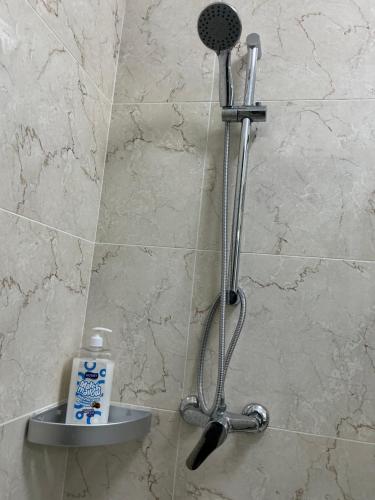 una ducha con cabezal de ducha en un baño en Mimahs Cozy Getaway near JKIA&SGR at NewRise Gardens, en Nairobi