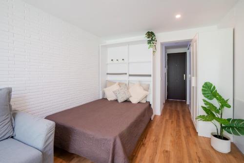 ein kleines Schlafzimmer mit einem Bett und einer Couch in der Unterkunft Sun Beach Delfín Verde Apartamento E11 in Benalmádena