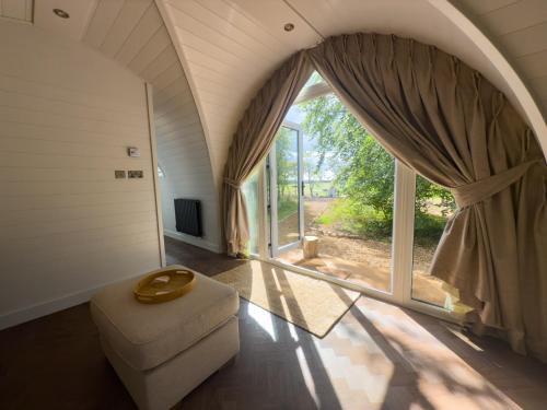 a living room with a large window and a chair at Liba Vineyard in Porton