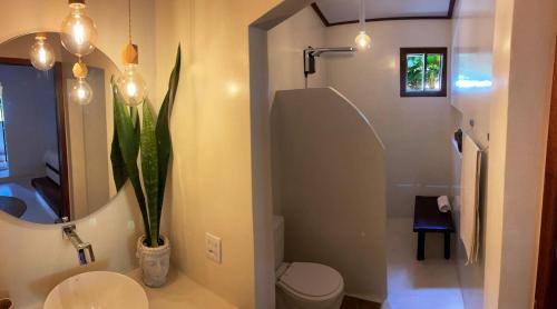 a bathroom with a toilet and a sink and a plant at Casa Positano Pipa in Pipa