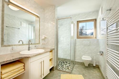 W łazience znajduje się umywalka, prysznic i toaleta. w obiekcie Appartements Luegeck w mieście Hollersbach im Pinzgau