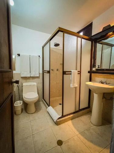 a bathroom with a shower and a toilet and a sink at Hostal San Francisco in San Cristóbal