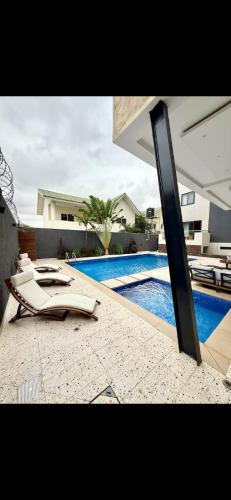 ein Pool mit einer Liege neben einem Schwimmbecken in der Unterkunft Stella Place in East Legon