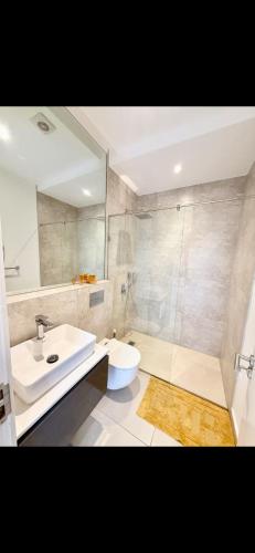 ein Badezimmer mit Waschbecken, Toilette und Dusche in der Unterkunft Stella Place in East Legon