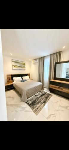 ein Schlafzimmer mit Bett und Flachbildfernseher in der Unterkunft Stella Place in East Legon