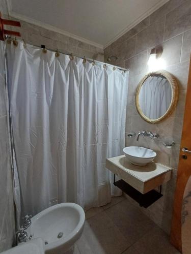 a bathroom with a white shower curtain and a sink at Cabaña Oliva in San Rafael