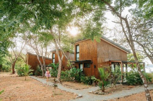 a little girl walking in front of a wooden house at Body - Oceanfront Jungle Loft in Playa Venao