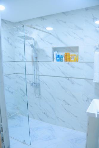 a bathroom with a shower with white marble walls at Yasmine Elixir in Casablanca