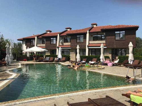 a pool in front of a house with people in it at Семеен хотел Звезда in Sŭdievo