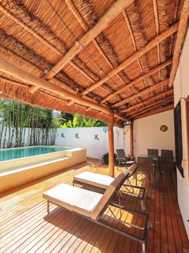 a patio with a table and chairs on a wooden deck at Casa alado de la playa in Cancún