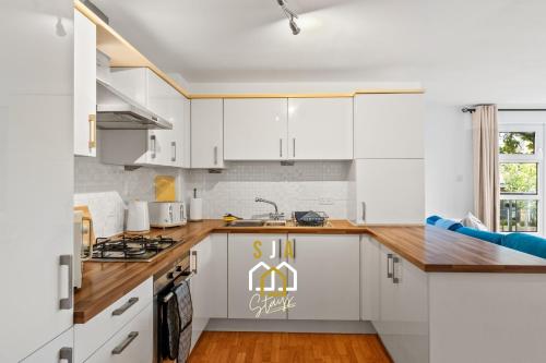 a kitchen with white cabinets and wooden counter tops at Hammerman Residence - SJA Stays - 3 Bed Apartment With Parking in Aberdeen