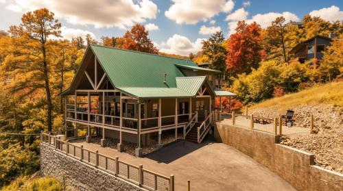 a house on a hill with a green roof at New Luxury Lodge - Gatlinburg - Mountain View! in Gatlinburg