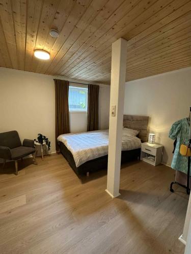 a bedroom with a bed and a chair in it at Leilighet i i vakre Skivika, Bodø Gratis parkering og rolige omgivelser nært sentrum in Bodø