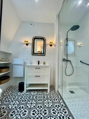 a bathroom with a sink and a glass shower at Charmante petite maison d'exception classée in Saint-Brieuc