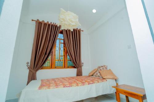 a bedroom with a bed and a window at Joy Villa Garden in Batticaloa