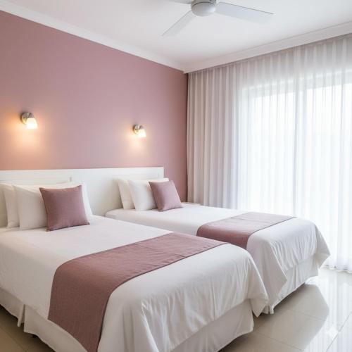 two beds sitting next to each other in a bedroom at Hotel Santa Rosa in Oaxaca City
