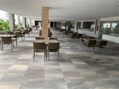 Un comedor con mesas y sillas en un edificio. en Park Veredas Apto 334, en Rio Quente