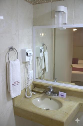 a bathroom with a sink and a mirror at Hotel Santa Rosa in Oaxaca City