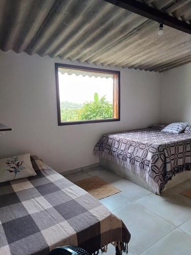 a bedroom with two beds and a window at Paraty Mirim - Refugio Montanha in Paraty