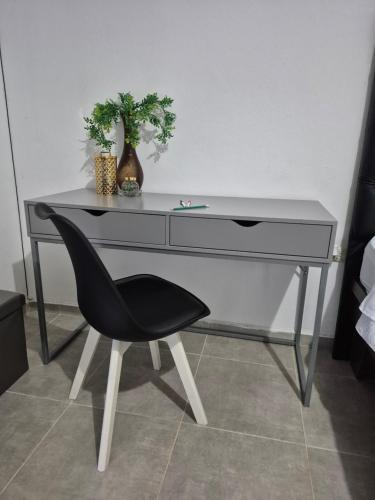 a desk with a black chair and a plant at OMY Apartments Nagua 1B in Nagua