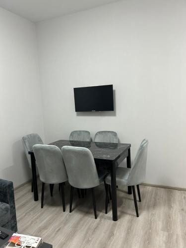 a dining room table with chairs and a television on a wall at Grigor's Guestgouse in Yerevan