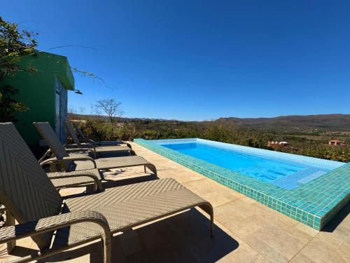 a pool with chaise lounge chairs and a swimming pool at Pousada Casa de Maitreya in Alto Paraíso de Goiás