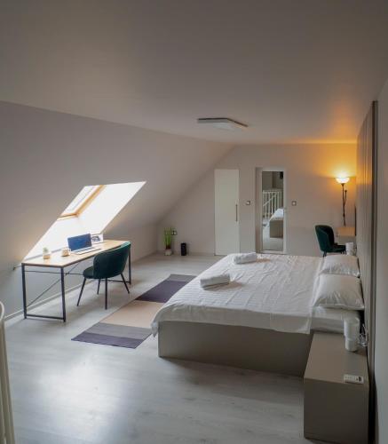 ソフィアにあるModern Vitosha View Apartment with Free Parkingのベッドと机のある白い寝室