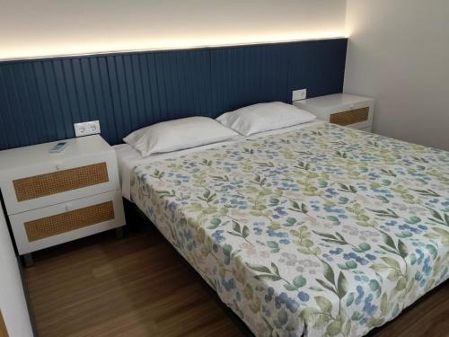 a bedroom with a bed with a floral comforter at Quinta da Estacao in Marco de Canavezes