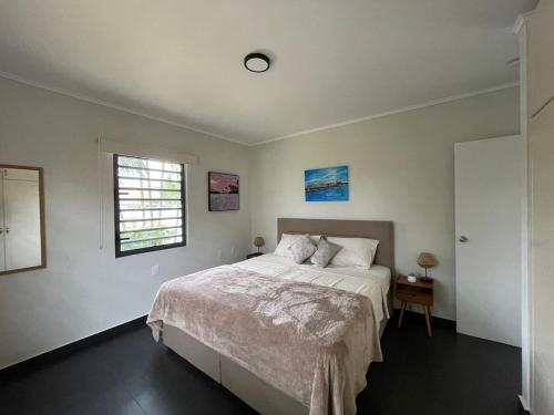 a bedroom with a large bed and a window at CasaPuru-at-JanThiel in Jan Thiel