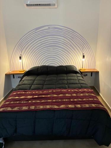 a bedroom with a large bed with two lamps at Colibrí - Smart Hostel in San Juan