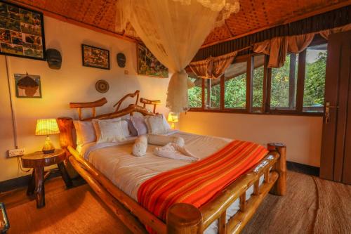 a bedroom with a large bed in a room with windows at Gorilla Retreat Ecolodge -Bwindi Forest in Bwindi