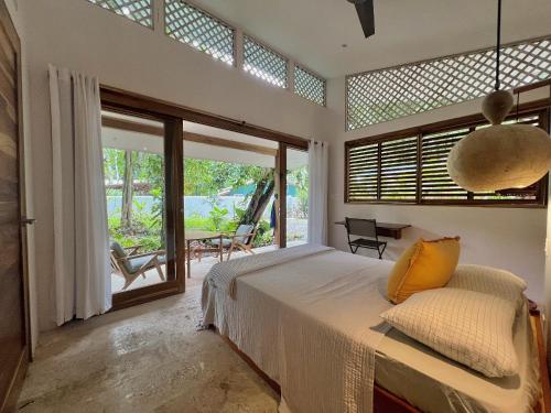 a bedroom with a bed and a large window at Villa Guaitil in Punta Uva