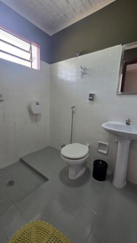 a bathroom with a toilet and a sink at Hotel Barretos Express in Barretos