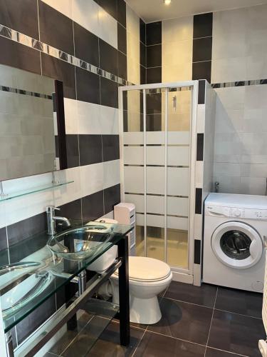 a bathroom with a sink toilet and a washing machine at Petite maison cœur de ville de La Teste de Buch in La Teste-de-Buch