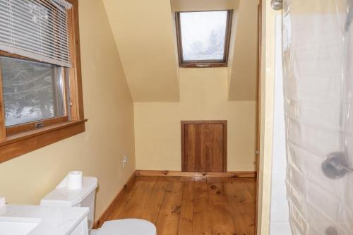 Un baño con inodoro, lavabo y ventana. en The Whimsical Chalet, en Mount Holly