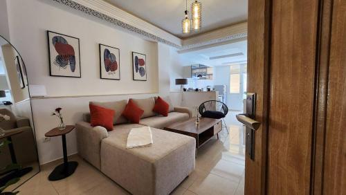 a living room with a couch and a table at Cosy and central Condo with terace in Rabat
