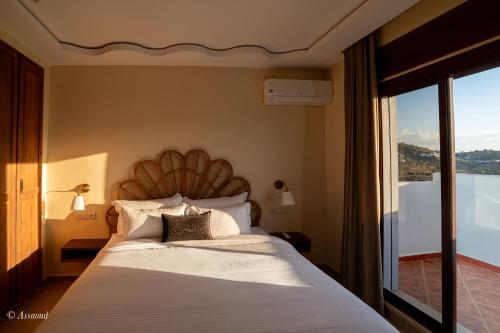 a bedroom with a large bed with a large window at Ain Chaouen in Chefchaouene
