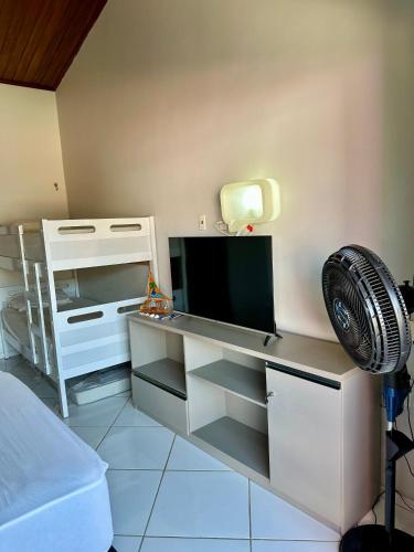 Pokój z biurkiem, telewizorem i wentylatorem w obiekcie Flat dboa w mieście Jericoacoara