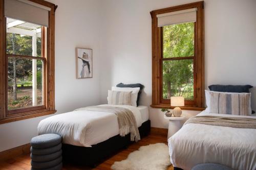 two beds in a room with two windows at Moragoe Homestead in Werona