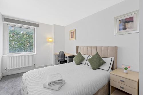 a bedroom with a bed and a desk and a window at Ensuite Room in Canary Wharf with attached Bathroom in London