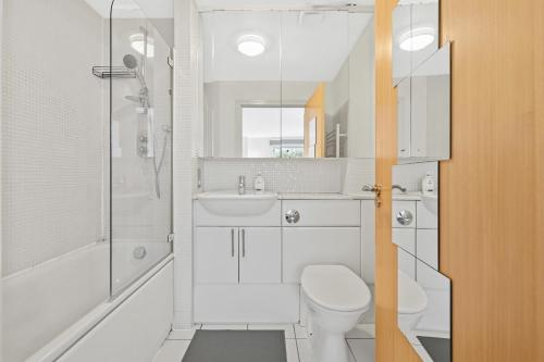 a white bathroom with a toilet and a shower at Ensuite Room in Canary Wharf with attached Bathroom in London