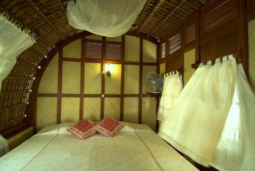 a bed with two pillows on it in a room at Spice Coast Cruises - Houseboat, A CGH Earth Experience in Alleppey