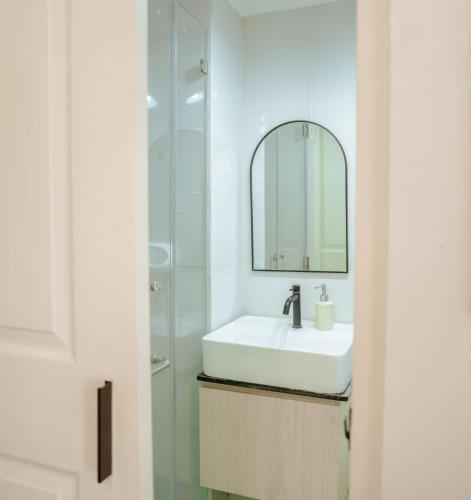 a bathroom with a sink and a mirror at SuiteEscape in Iloilo City