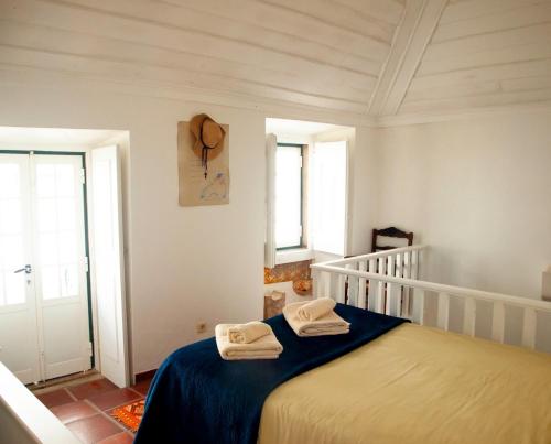 a bedroom with a bed with two towels on it at Charming Coastside Villa in Colares