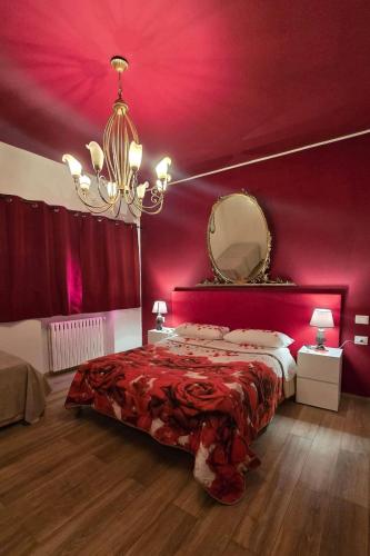 a bedroom with a red wall with a bed and a mirror at Samamà House in Taranto