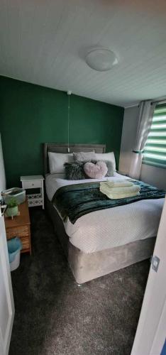 a bedroom with a bed with a green wall at 27 bucklands in Bideford