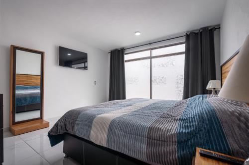 a bedroom with a bed and a large window at Casa Adul Chignahuapan in Chignahuapan