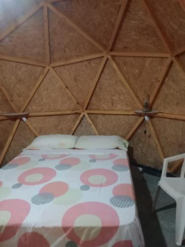 a room with a bed and a chair in a yurt at EL ENCUENTRO Domo Geodesico in Miramar