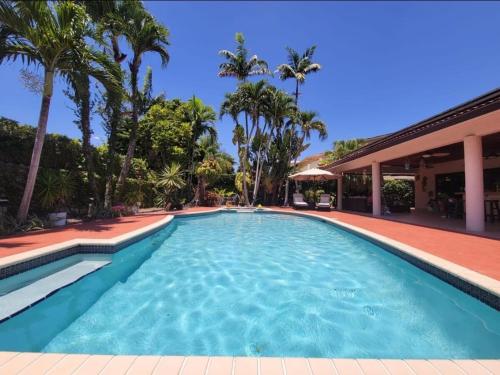 Una piscina con palmeras y un edificio. en My Tropical Paradise with pool in Miami, en Tamiami